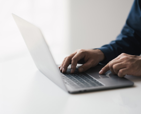 Side view of someone typing on laptop computer